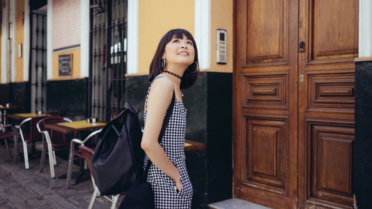 A girl is looking up and smiling on the street; image used for "free up funds" article.