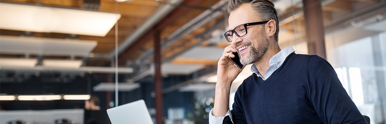 a businessman is talking over the phone in office; image used for HSBC Sri Lanka ways to bank phone banking