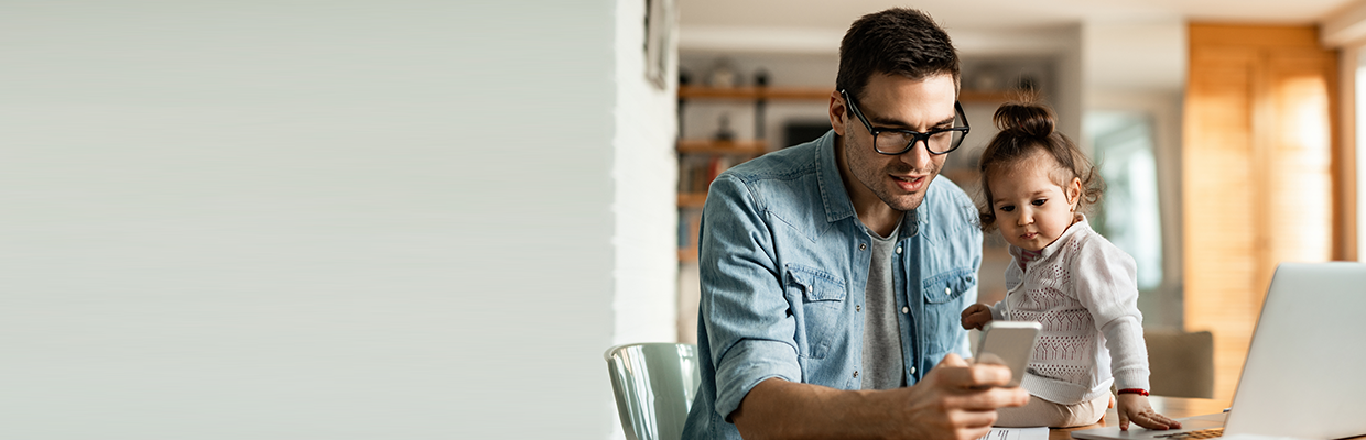 A man together with his little girl looking and his mobile phone; image used for HSBC LK mobile banking page.